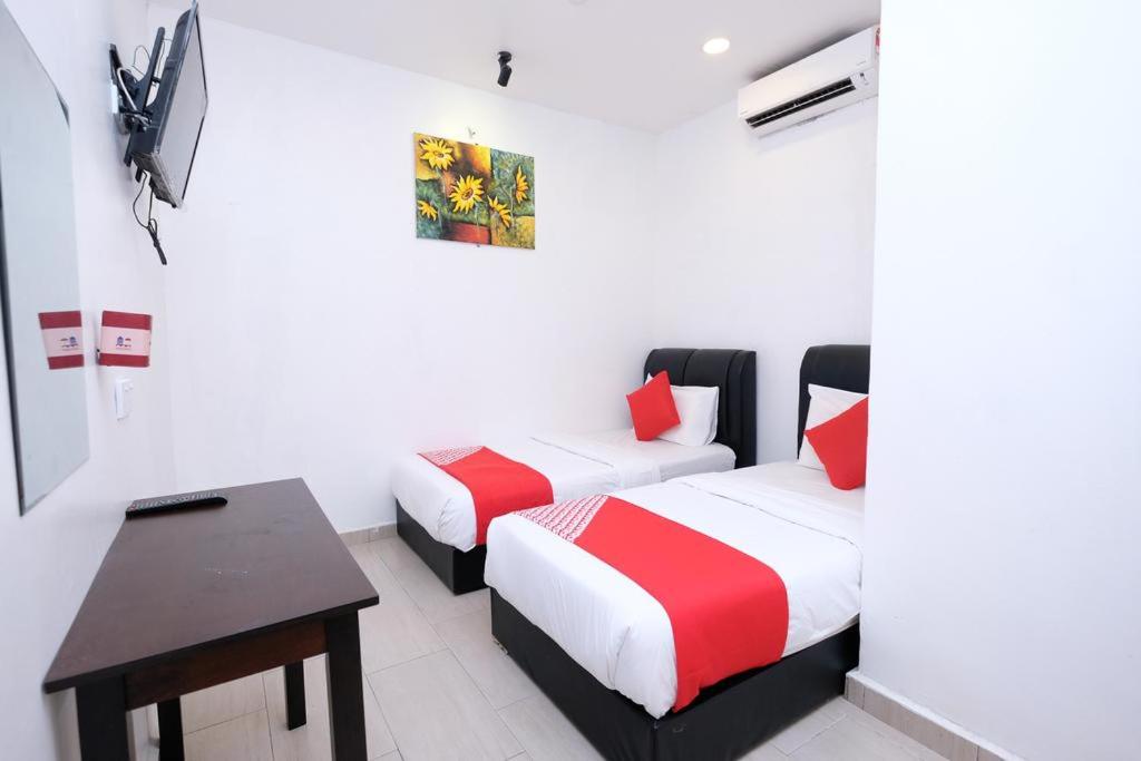 Cette chambre comprend 2 lits et un bureau. dans l'établissement MRJ Hotel Wakaf Che Yeh 1, à Kota Bharu