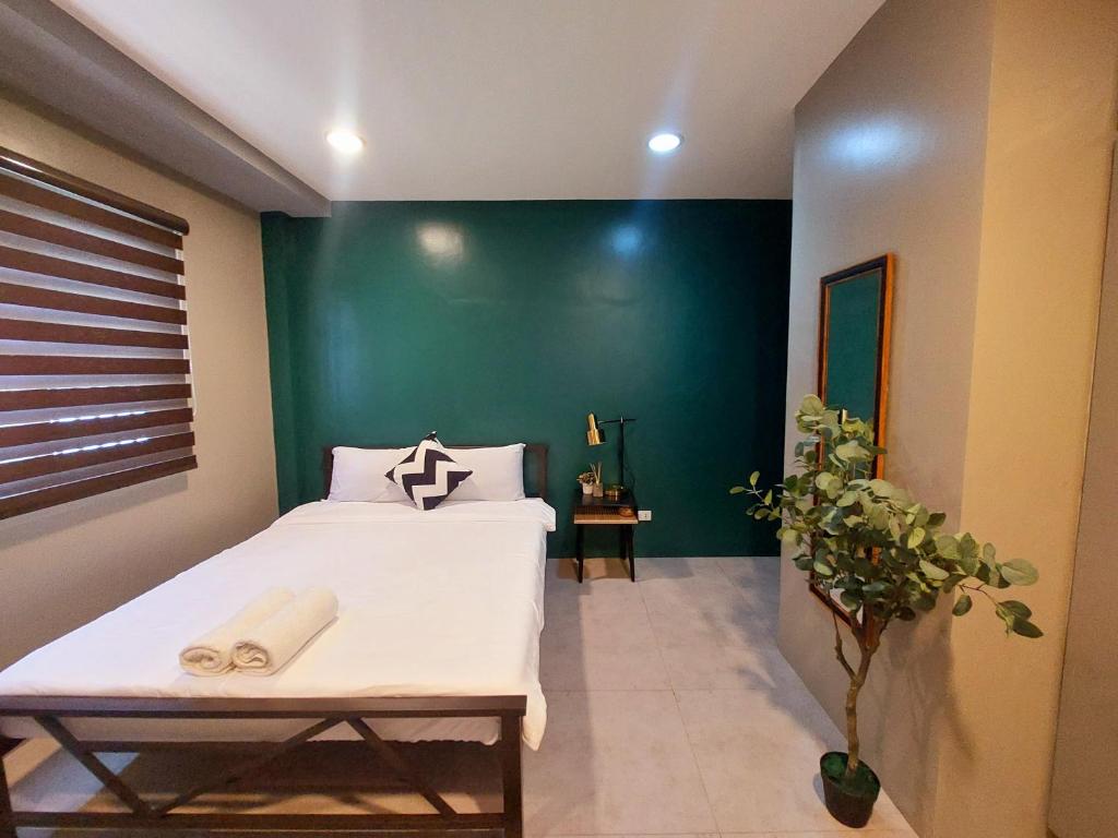 sypialnia z łóżkiem i zieloną ścianą w obiekcie Minimalist Vigan Condo Near Calle Crisologo w mieście Vigan