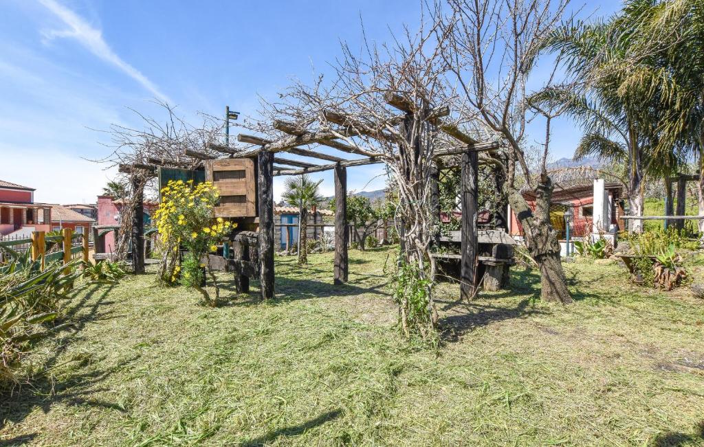 um jardim com um arco de madeira na relva em Amazing Home In Santa Venerina With Wifi em Santa Venerina