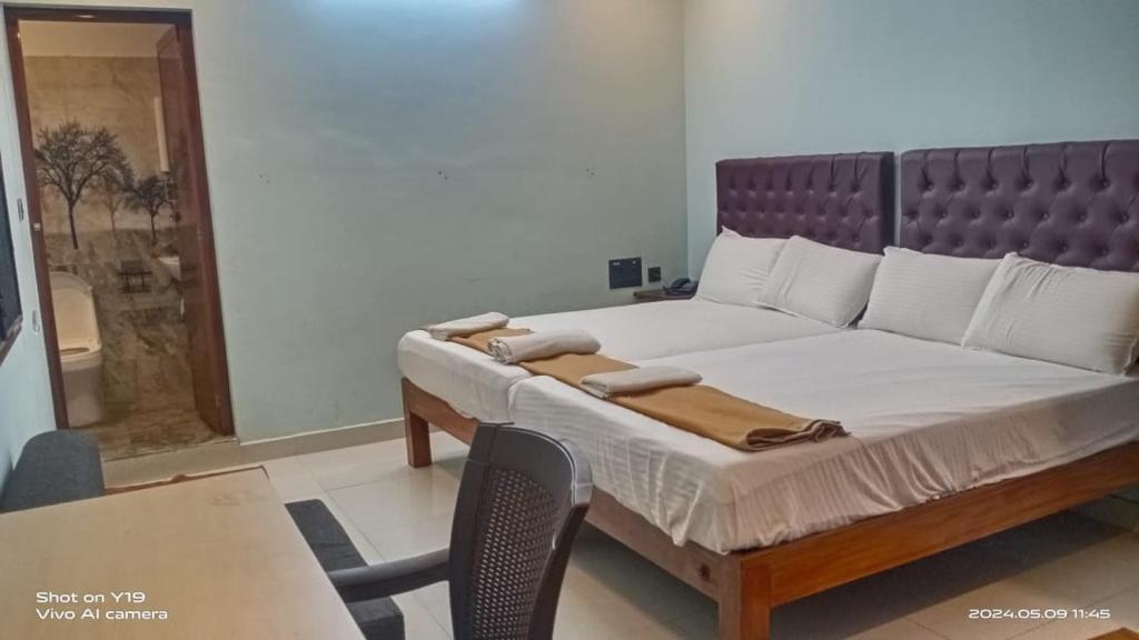 a bedroom with a bed and a table and a chair at Tru Comfort in Puducherry