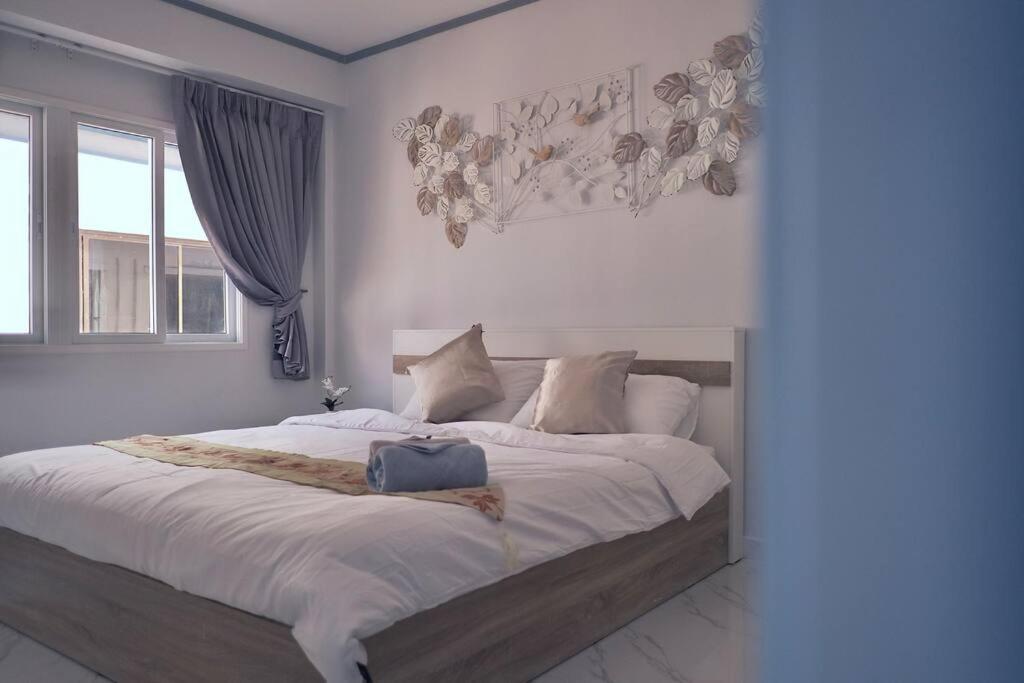 Un dormitorio con una cama grande con sábanas blancas. en KataBeach sweetHome 4br, en Kata Beach
