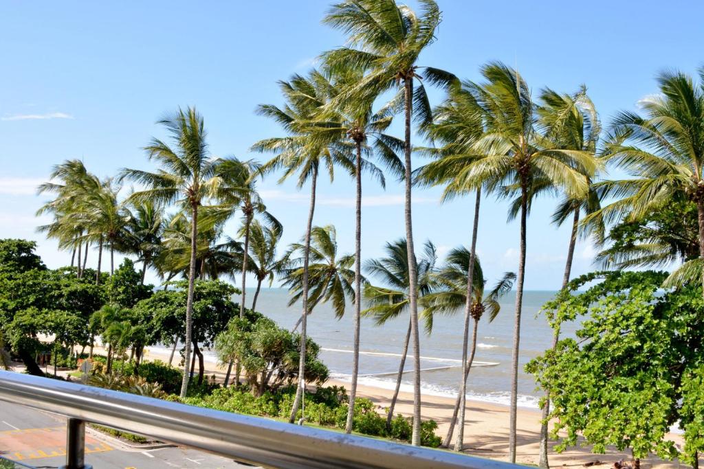 三一海滩Beachfront 3-Bed with Pool & Stunning Ocean Views的享有棕榈树海滩和道路的景色