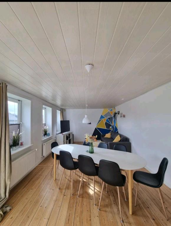 a living room with a dining room table and chairs at Willkommen in Frifelt Nähe Rømø mit wunderschönen Garten in Skærbæk