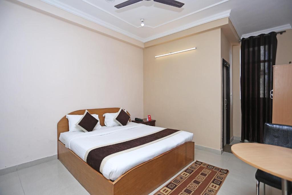 a bedroom with a bed and a table and a desk at OYO 10216 Hotel UK Retreat in Bhowāli