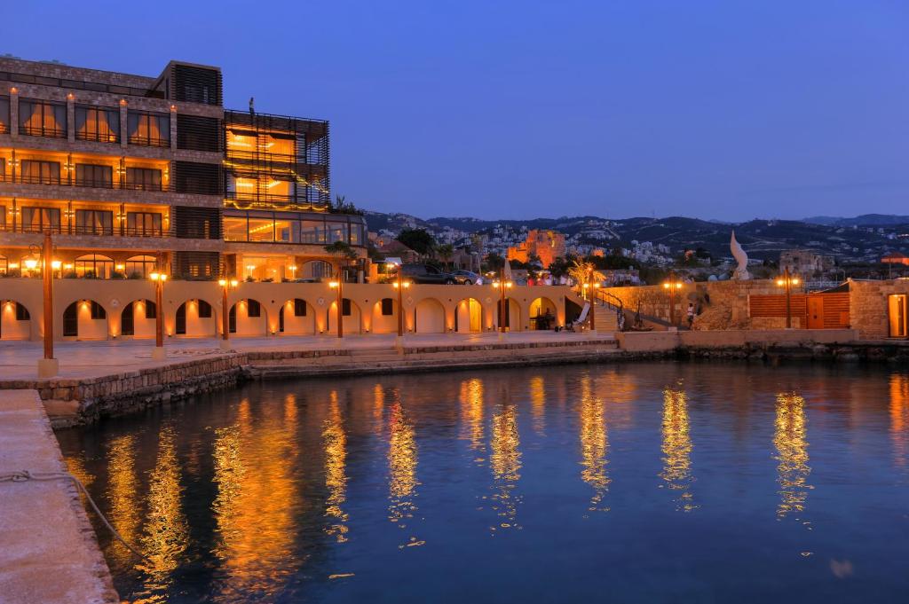 um edifício ao lado de um corpo de água à noite em Byblos Sur Mer em Jbeil