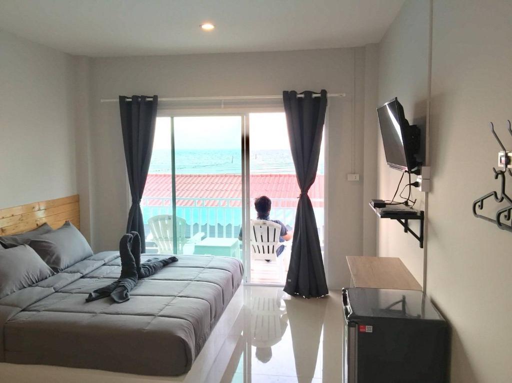 a bedroom with a bed and a view of the ocean at Seasmile kohlarn in Ko Larn