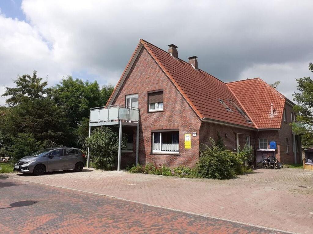 a house with a car parked in front of it at "Baltrum" Comfortable holiday residence in Hooksiel