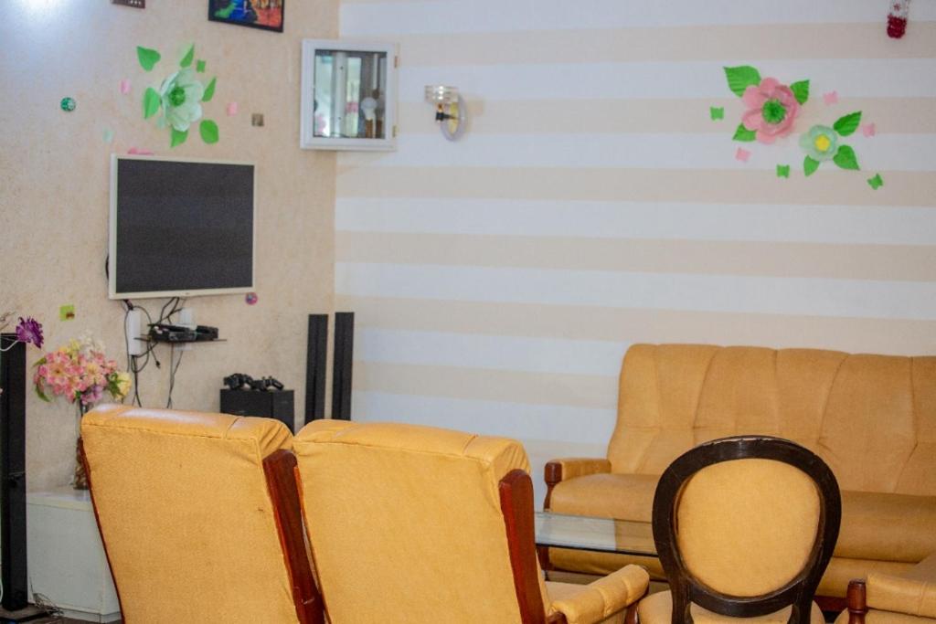 - un salon avec deux chaises et une télévision à écran plat dans l'établissement House of ours Dreams, à Abomey-Calavi