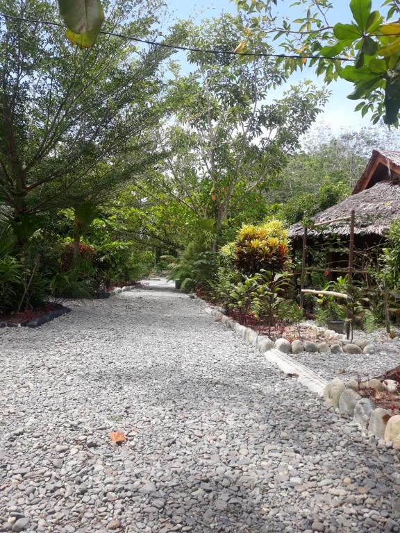a gravel path in a garden with a building at Magpie homestay in Bukit Lawang
