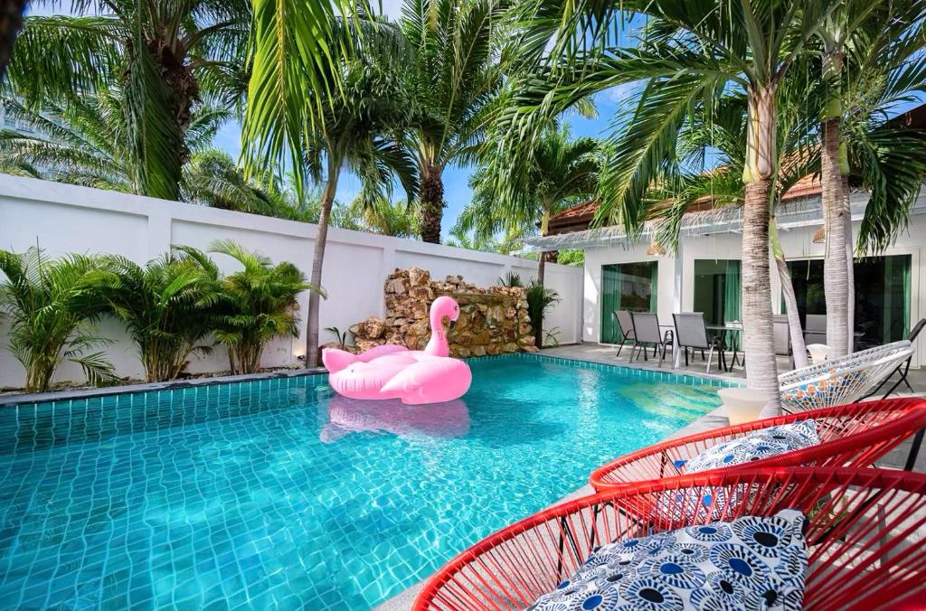 una piscina con un flamenco rosa inflable en un complejo en Majestic Residence Pool Villa 4 Bedrooms Private Beach en Pattaya South