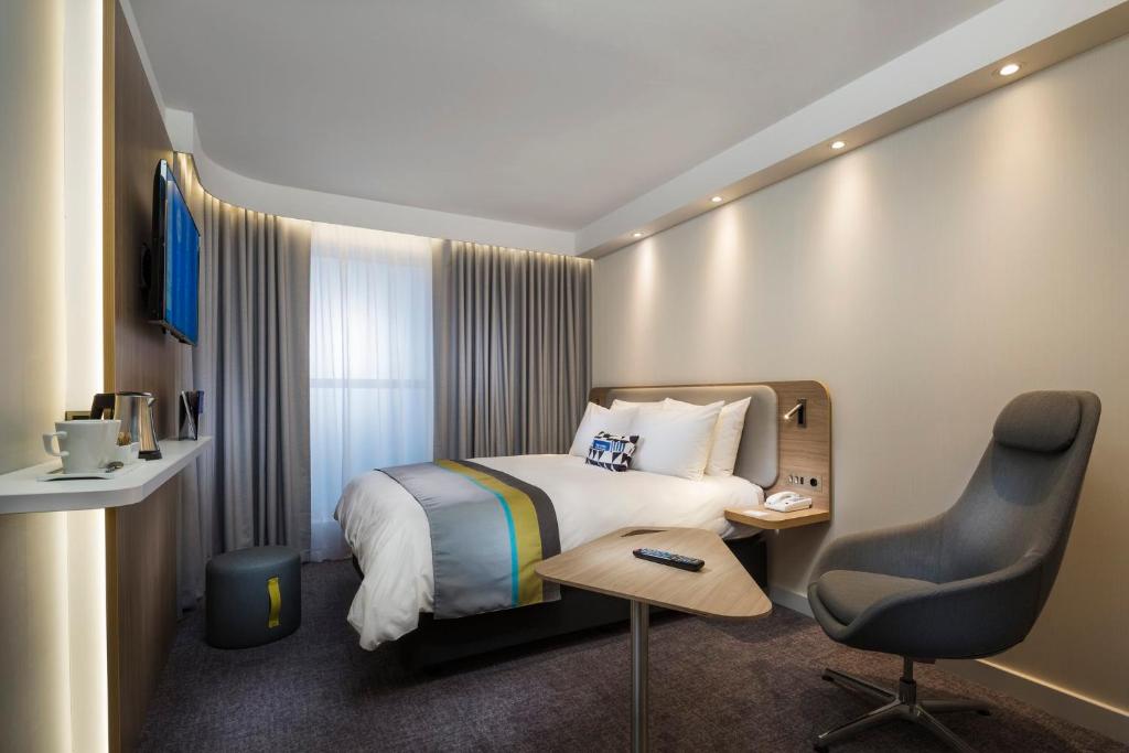a hotel room with a bed and a desk and a chair at Holiday Inn Express Ajaccio by IHG in Ajaccio