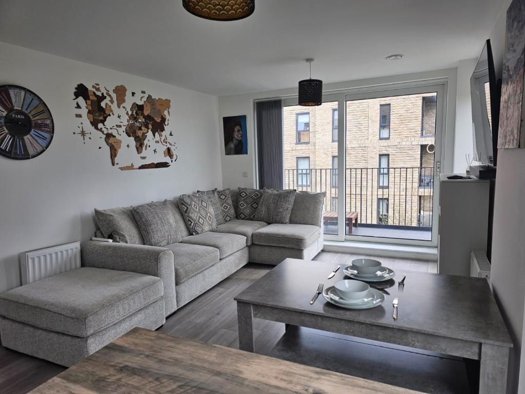 uma sala de estar com um sofá e uma mesa de centro em Luxury 1-Bed Apartment with balcony & Free parking em Milton Keynes