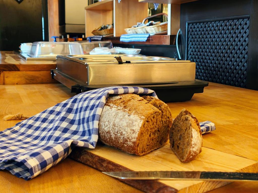 a loaf of bread on a cutting board with a knife at A8 Hotel im Darchinger Hof, Bed & Breakfast in Weyarn