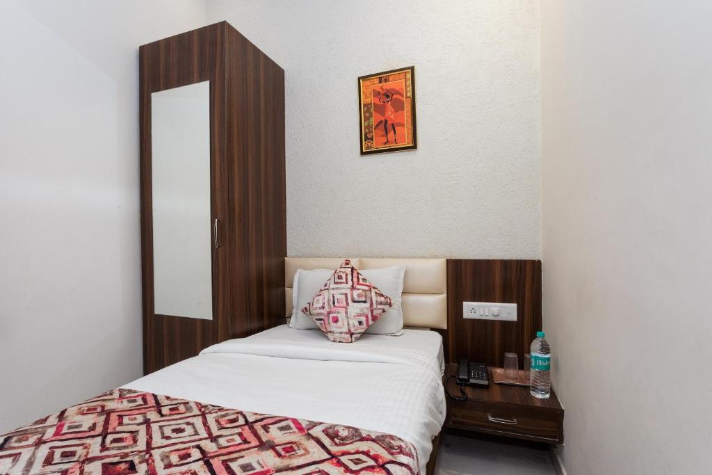 ein Schlafzimmer mit einem Bett und einem Tisch mit einem Kissen in der Unterkunft OYO Flagship Hotel Shri Vilas in Bhopal