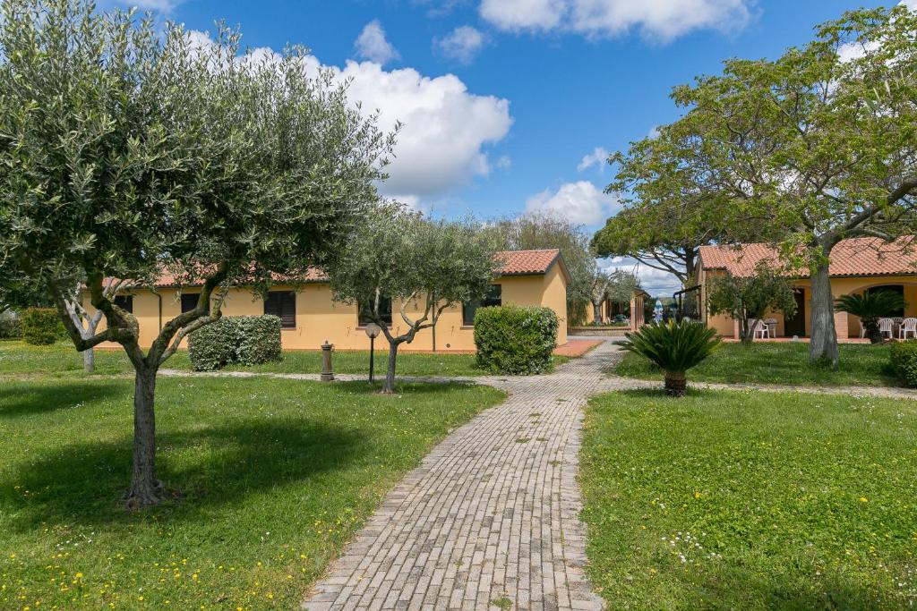 een bakstenen pad voor een huis met bomen bij Il Girasole - Ginestra in Venturina Terme