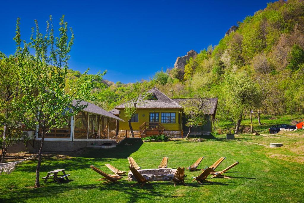 Ein Haus mit einem Haufen Stühle im Hof in der Unterkunft Alunis Retreat in Aluniş
