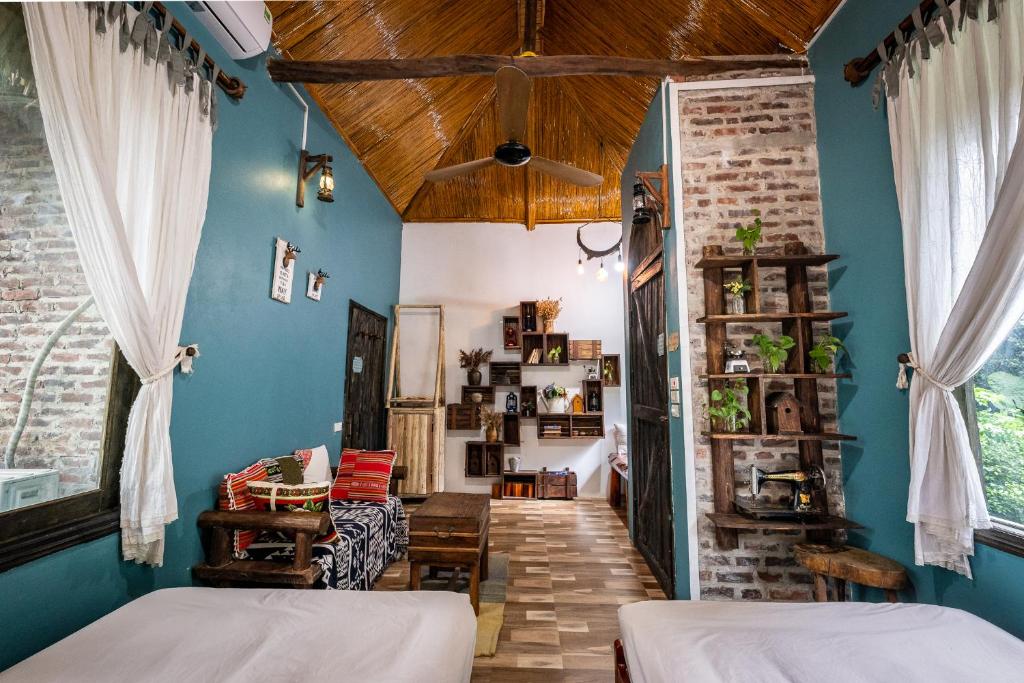 een slaapkamer met 2 bedden en een blauwe muur bij Lim's house in Mai Chau