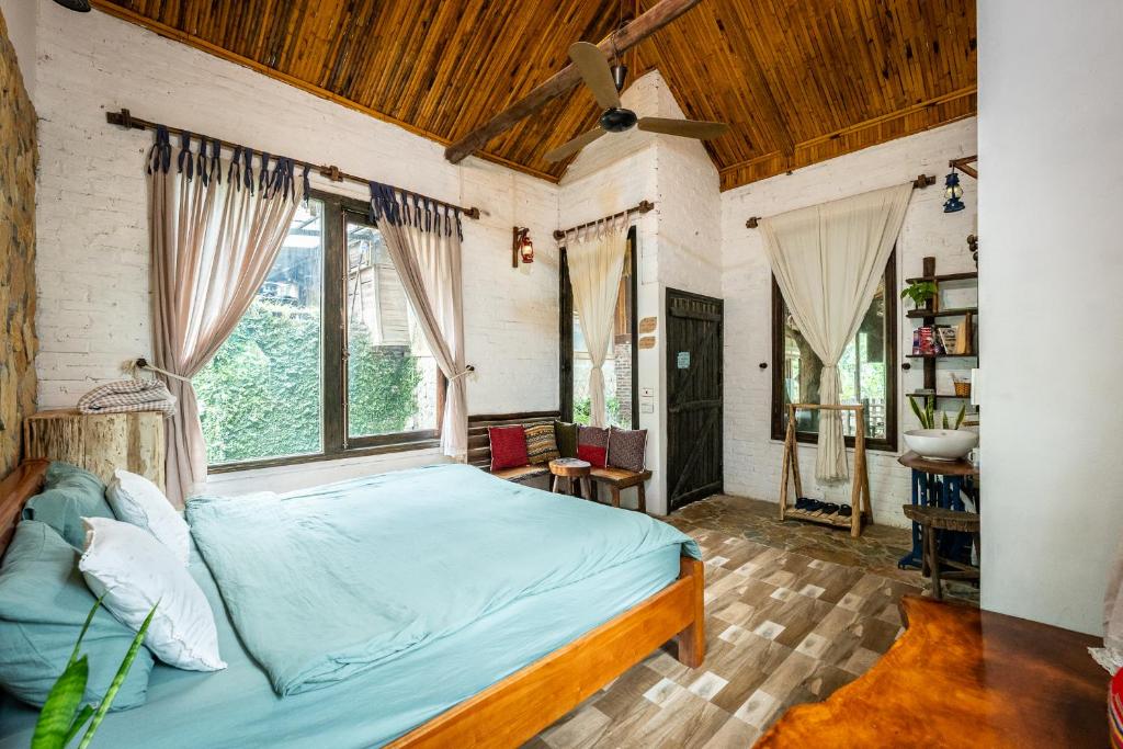 Un dormitorio con una cama en una habitación con ventanas. en Lim&#39;s house, en Mai Chau