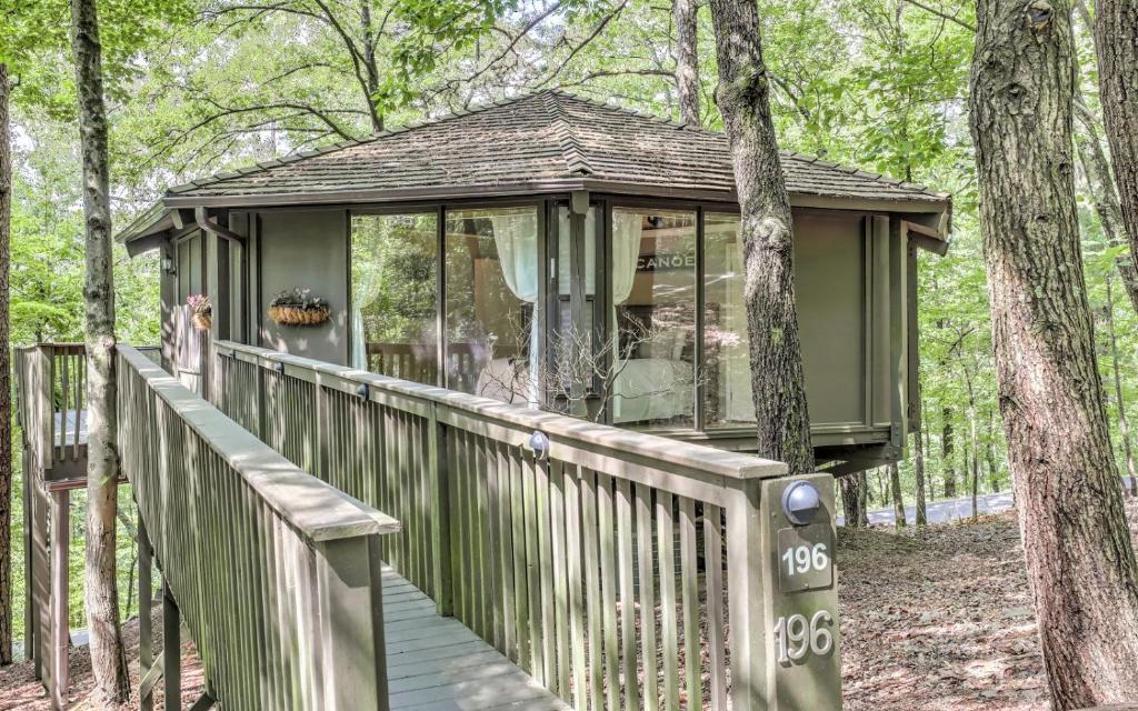 a house with a wooden deck in the woods at Treetopper Hideaway - A Relaxing Chic Bungalow in Marblehill