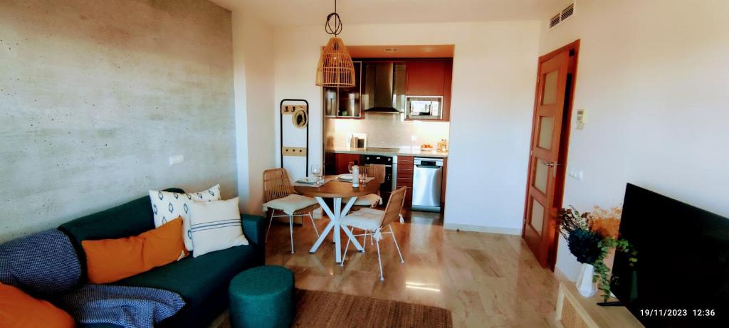a living room with a couch and a table and a kitchen at L'Ampolla, sol y mar in L'Ampolla