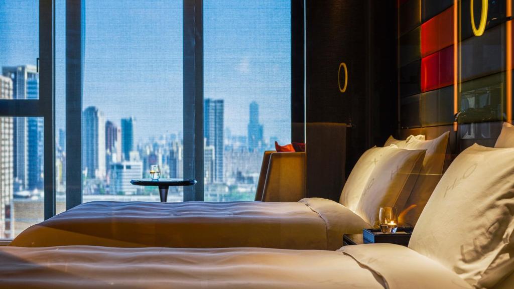 a hotel room with a bed and a large window at H2O HOTEL in Kaohsiung