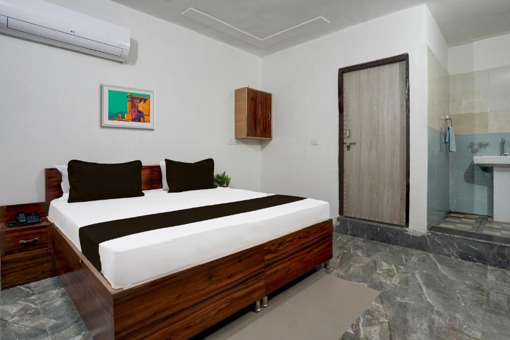 1 dormitorio con 1 cama grande y baño en OYO Hotel Royal Park, en Alwar