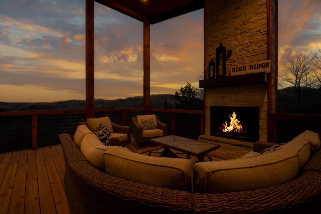 - une terrasse couverte avec des canapés et une cheminée dans l'établissement Quiet Time - Gorgeous Mountain Views Chic Interiors Wood-burning Fireplace, à Blue Ridge