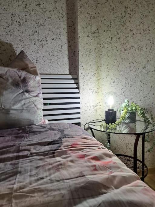 a bedroom with a bed and a table with a lamp at Haus in der ruhigen Siedlung in Sztum