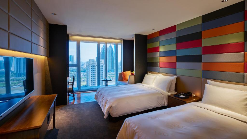 a hotel room with two beds and a large window at H2O HOTEL in Kaohsiung