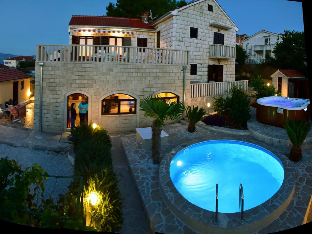 a swimming pool in front of a house at Apartments " Happy villa " in Splitska