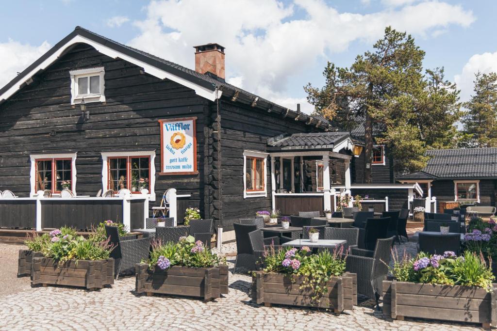 a building with tables and chairs in front of it at Gammelgården in  Högfjället