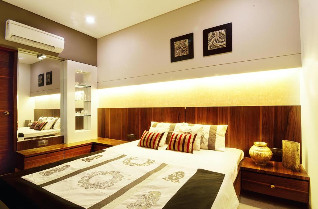 ein Schlafzimmer mit einem großen Bett und einem Spiegel in der Unterkunft Roomsity Pride Delhi in Neu-Delhi