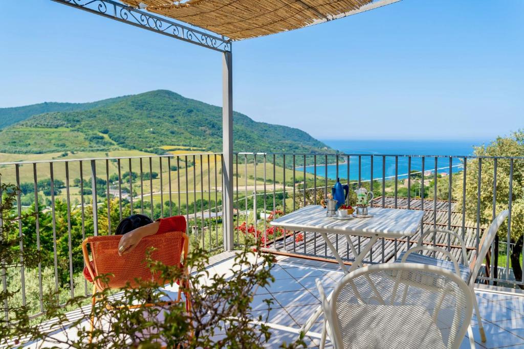 balcón con mesa, sillas y vistas al océano en B&B Baia Di Trentova, en Agropoli