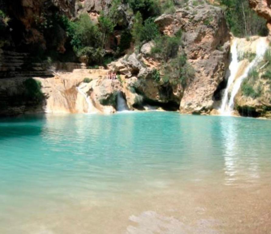 una gran piscina de agua azul con cascada en Apartamento Rurales El Mirador de Carboneras, en Carboneras de Guadazaón