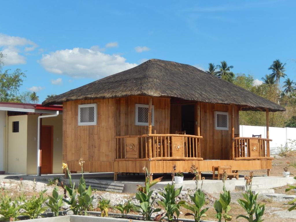 a wooden house with a thatched roof at Sunset Garden Lambug Badian in Badian