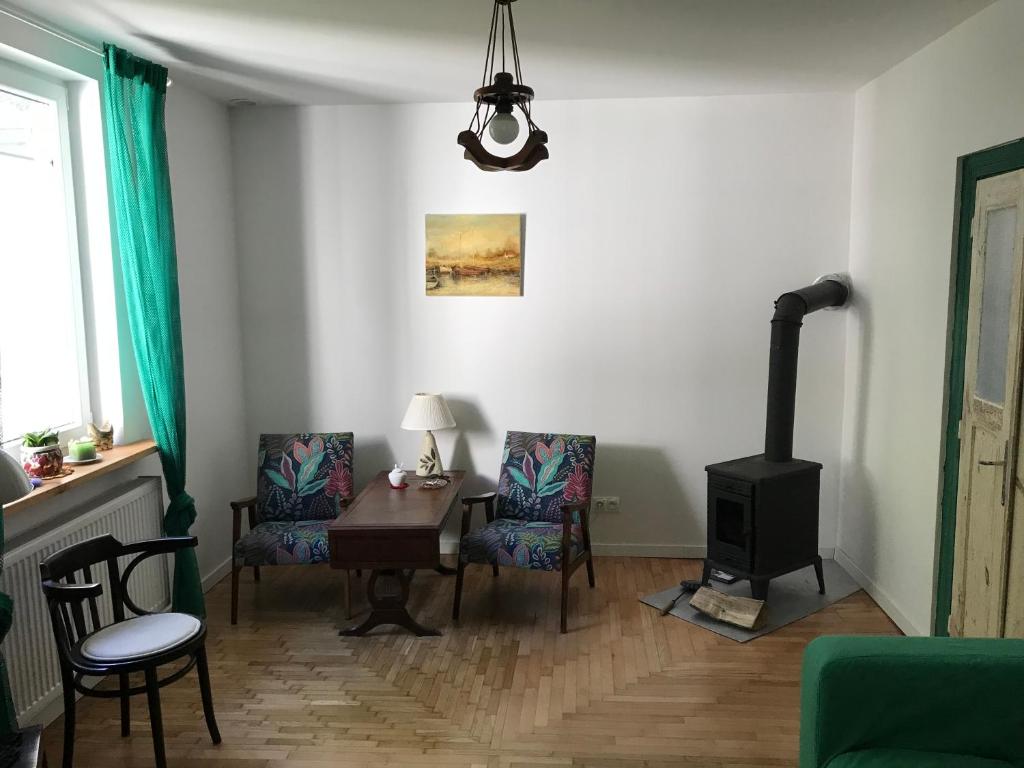 ein Wohnzimmer mit einem Tisch, Stühlen und einem Herd in der Unterkunft Augustówka - letnisko na Wrzosowiskach 