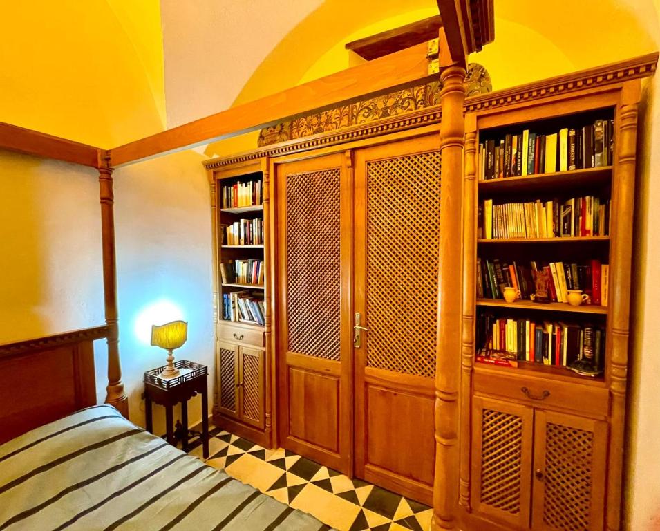 um quarto com uma cama e estantes de livros com livros em Dar Aziz em Sousse