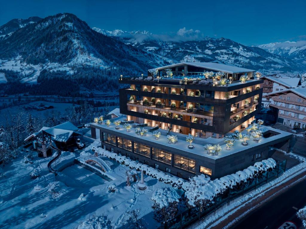 um hotel nas montanhas com neve no chão em Hotel Berghof - St Johann in Salzburg em Sankt Johann im Pongau