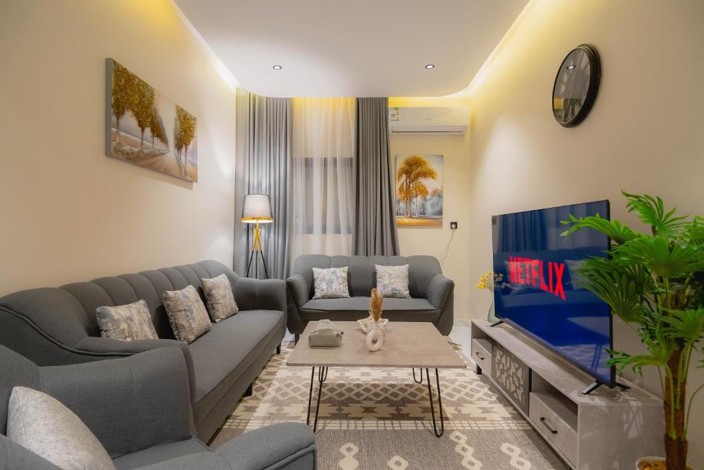 ein Wohnzimmer mit einem Sofa und einem TV in der Unterkunft شقة بصالة وغرفة نوم ودخول ذاتي 8B in Riad