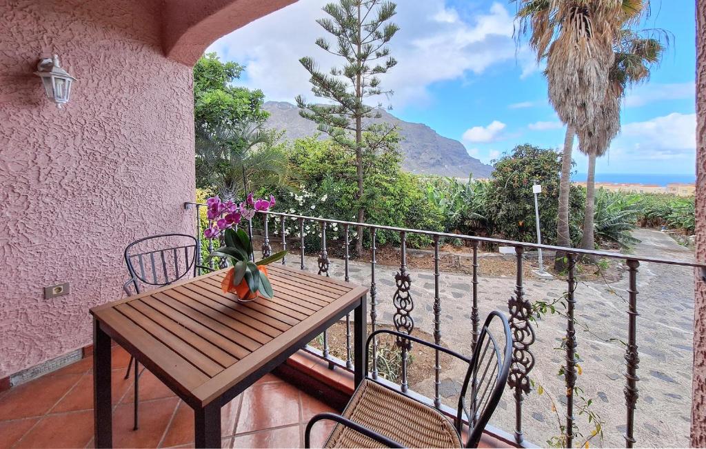 una mesa de madera en un balcón con vistas al océano en Nice Home In Buenavista Del Norte, en Buenavista del Norte