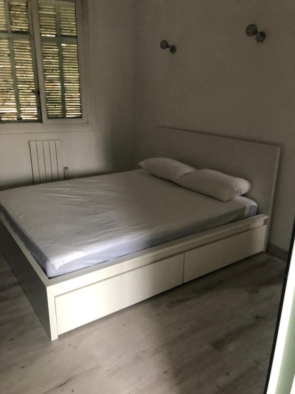 Magnifique T2 bien desservi في مارسيليا: سرير في غرفة ذات إطار سرير أبيض