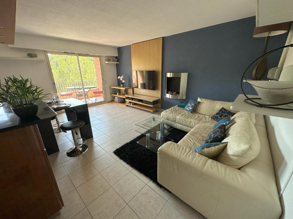 un salon avec un canapé blanc et une table en verre dans l'établissement Superbe 3pièces, balcon, garage, clim, piscine, à Mougins