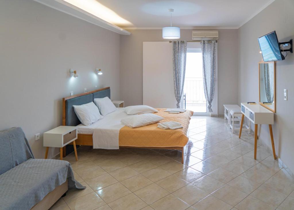a bedroom with a large bed and a couch at Ermioni Rooms in Paralia Vrachou