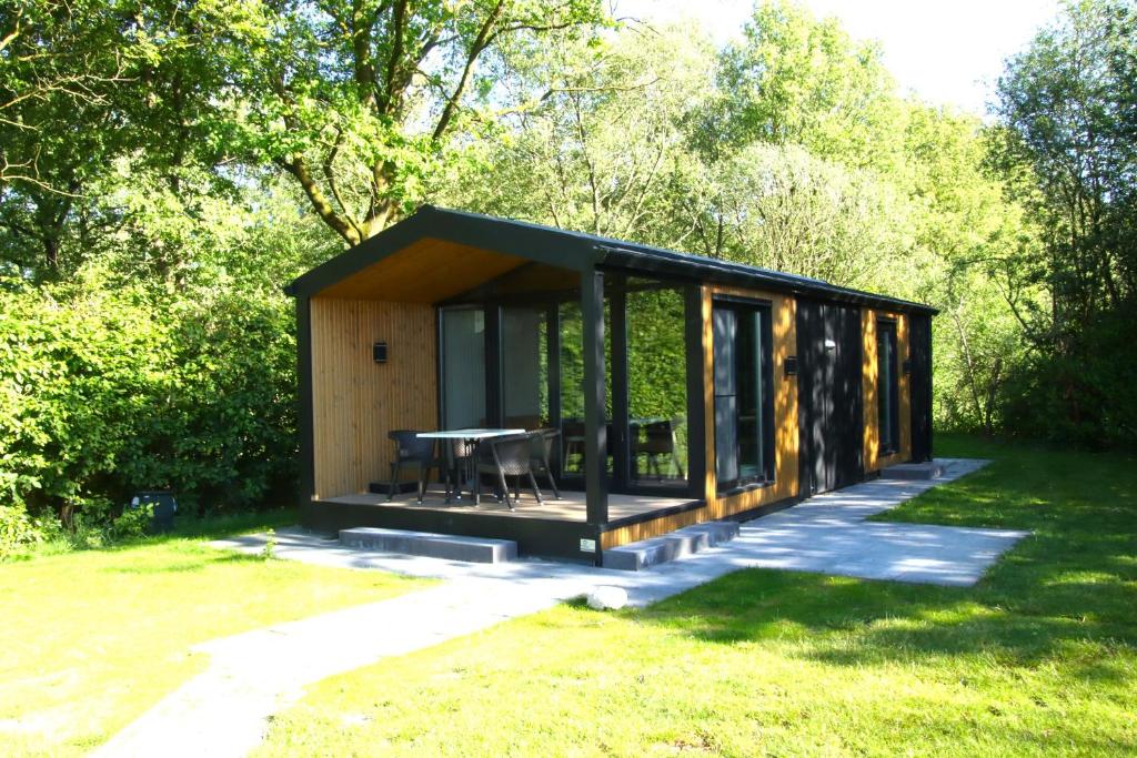 une petite cabine avec une table dans l'herbe dans l'établissement Chalet Lodge, à Drijber