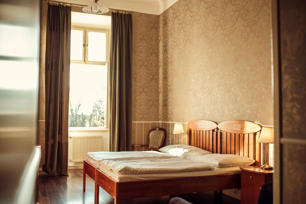 Postel nebo postele na pokoji v ubytování Hotel Kaštieľ Mojmírovce