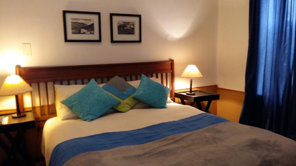a bedroom with a bed with blue and green pillows at Albertinia Hotel in Albertinia