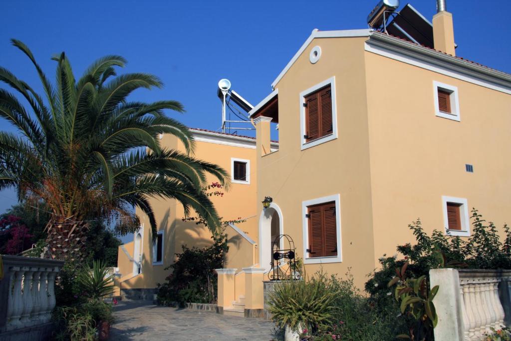 a house with a palm tree in front of it at Villa Helen in Arillas