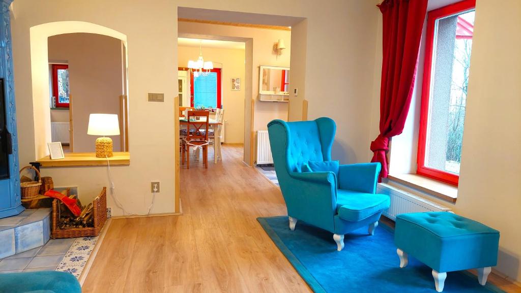 una sala de estar con 2 sillas azules y una ventana en Five maple home for families and wild nature lovers, en Měděnec