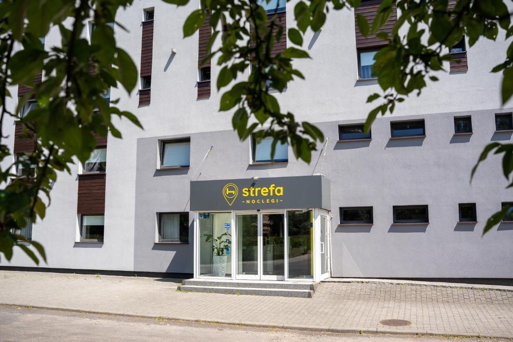 un edificio con una señal delante de él en Aparthotel Strefa Premium, en Tychy