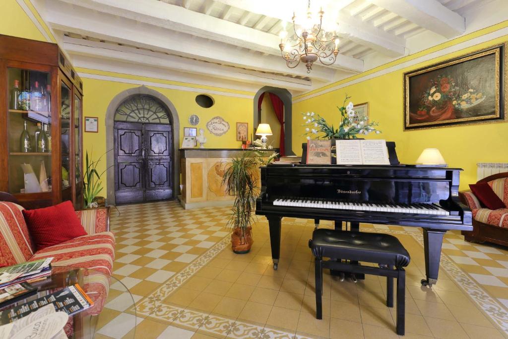 un soggiorno con pianoforte al centro di una stanza di Antica Dimora Patrizia a Montecarlo